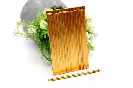Porta blocos em prata dourada com bandas relevadas ao alto e lapiseira acoplada.